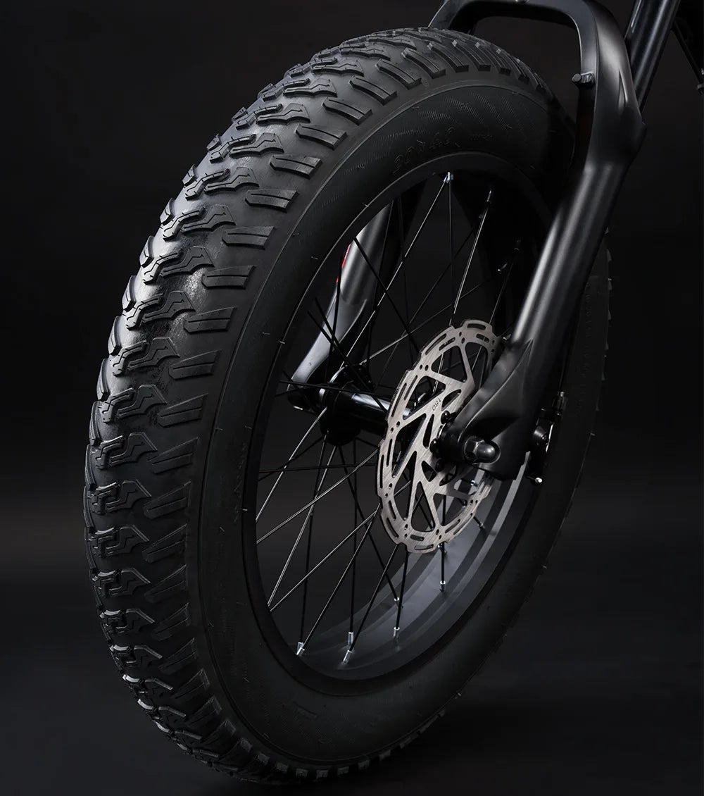 Close-up of a motorcycle tire with tread pattern on a dark background