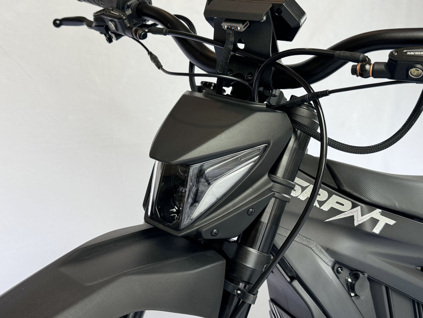 Close-up of a motorcycle's headlight and front part on a white background