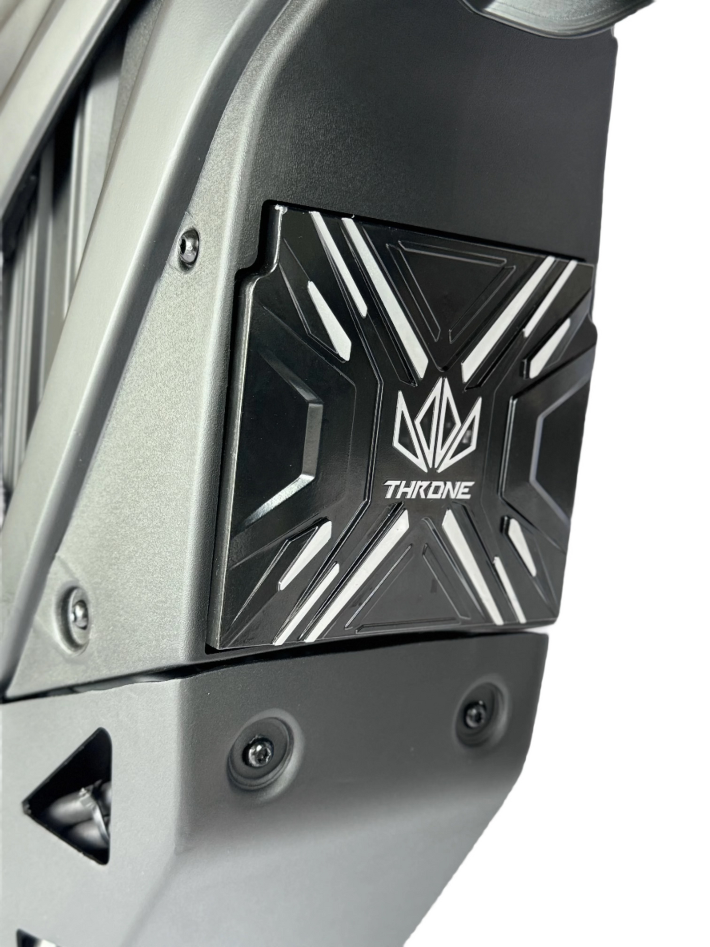 Close-up of a motorcycle exhaust with 'Throne' branding on a white background