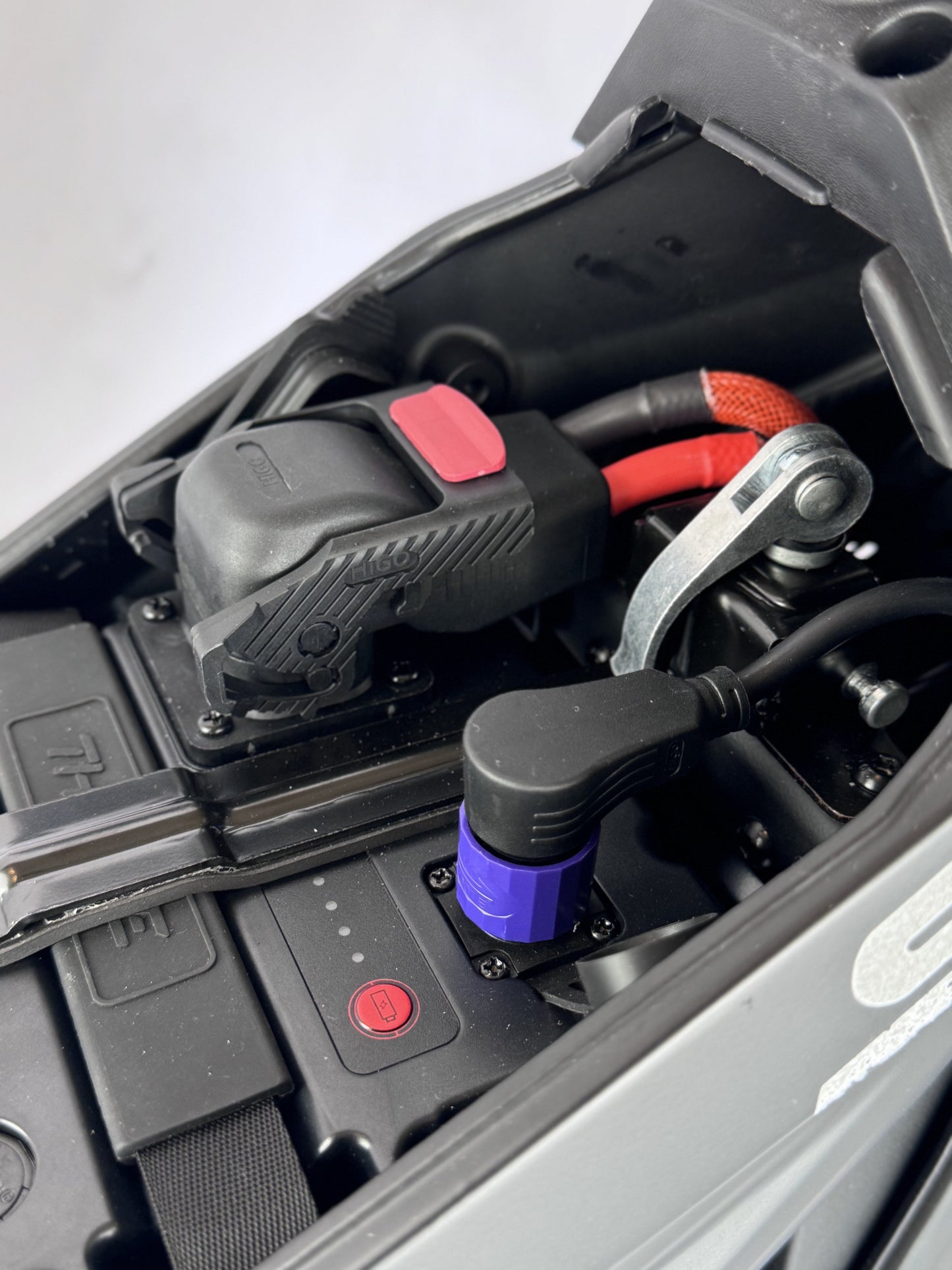 Close-up of a car battery with cables connected, on a white background