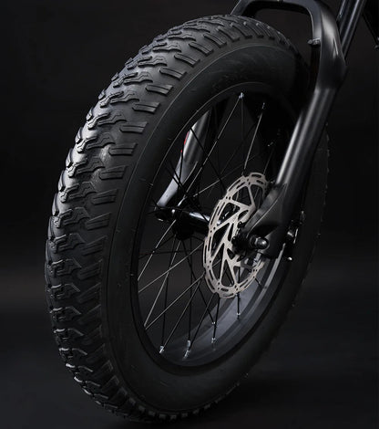 Close-up of a motorcycle tire with tread pattern on a dark background