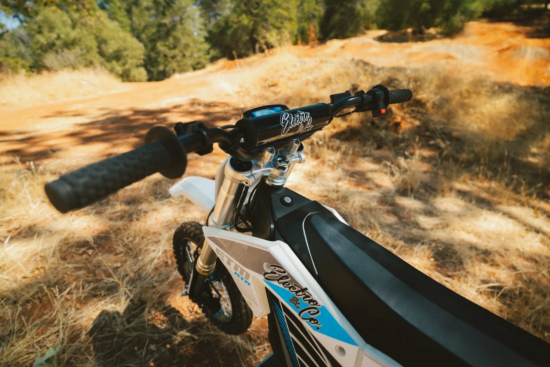 Close-up of a dirt bike handlebar with a natural outdoor background