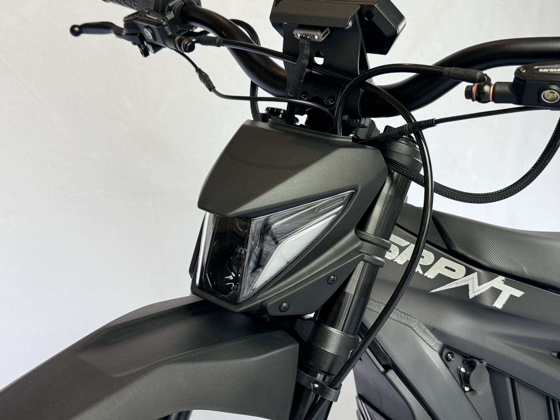 Close-up of a motorcycle's headlight and front part on a white background