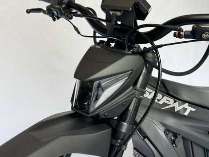 Close-up of a motorcycle's headlight and front part on a white background